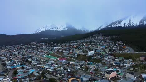 Drone-shot-flying-over-Ushuaia,-Argentina-towards-the-snow-covered-Andes-mountains