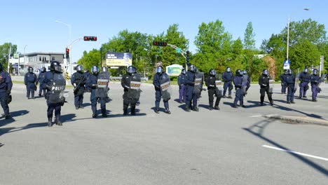 Panning-from-right-to-the-left-at-a-group-of-riot-police-deployed-in-the-middle-of-the-intersection-of-Québec-City,-in-preparation-for-the-G7-Summit-held-in-Québec,-Canada