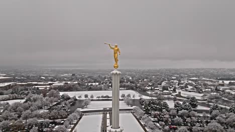 Aerial-parallax-around-golden-Angel-Moroni-on-top-of-Provo-LDS-Mormon-Temple-covered-in-snow