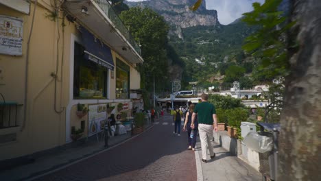 Amalfi-Positano-Italy-Immersive-Travel-Tourism-Mediterranean-Sea-Coast-Water-Europe,-Walking,-4K-|-Tourists-Walking-Exploring-Market-on-Roads-Below-Famous-Mountainside-Homes,-Shaky
