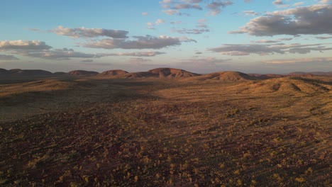 Beautiful-landscape-of-Australian-desert-with-rocky-mounts-in-background-at-sunset,-Karijini-Area-in-Western-Australia