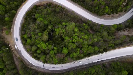 Drone-shot-ascending-over-a-winding,-curvy-road-going-up-the-Andes-mountains-in-Ushuaia,-Argentina