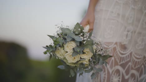 A-bride-holds-a-bouquet-of-flowers,-a-riot-of-color-and-texture