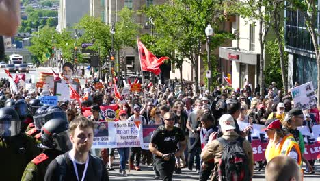 Eine-Gruppe-Von-Aktivisten-Auf-Einem-Protestmarsch-Durch-Die-Straßen-Von-Québec-City,-Während-Polizeikräfte-Die-Sicherheit-Aller-Menschen-In-Québec,-Kanada,-Gewährleisten