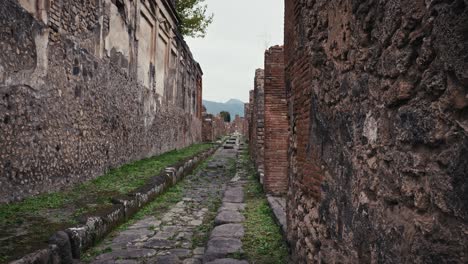 Ancient-Pompeii-Street-with-mount-Vesuvius-in-the-Distance,-Italy