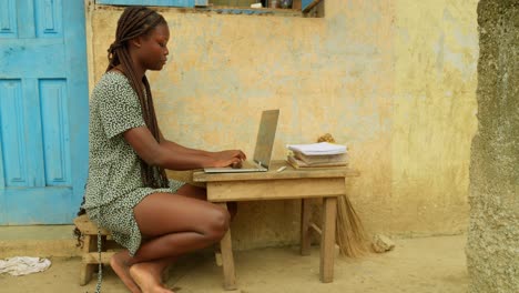 Browsing-the-internet-while-studying-online,-the-young-woman-is-getting-access-to-education-from-her-village-in-Kumasi,-Ghana,-in-Africa