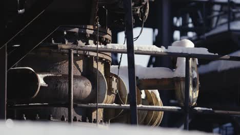 Close-up-of-rusted-machinery-that-is-part-of-a-larger-structure-consisting-of-pipes,-valves-and-tanks