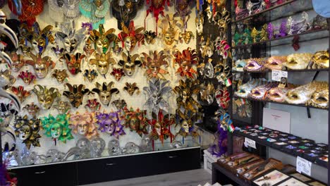 Venetian-masks-hanging-in-shop-for-Carnival-festivities-in-Venice,-Italy