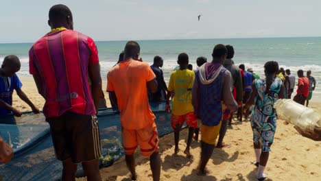 Afrikanische-Menschen-Arbeiten-Gemeinsam-Am-Strand-Mit-Fischernetzen