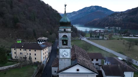 Aerial-Crane-Forward-Drone-shot-of-Bell's-Tower-Church-in-Pieve-di-Ledro---Trento