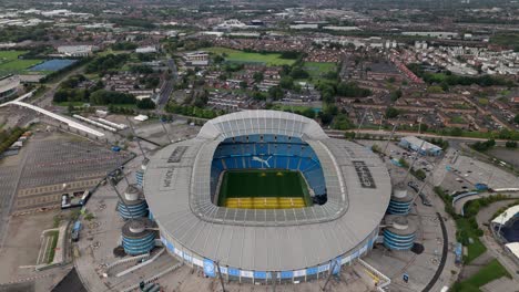 Aerial-tilt--down-over-Manchester-City-Football-Club,-Etihad-Stadium,-UK