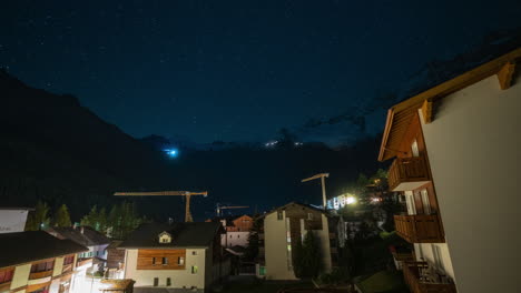 Saas-Fee-Village-Switzerland-Glacier-cinematic-time-lapse-Gletscher-Swiss-village-clear-deep-blue-night-star-sunrise-transition-morning-mountain-snow-making-cat-track-groomer-lights-up-and-down-crane