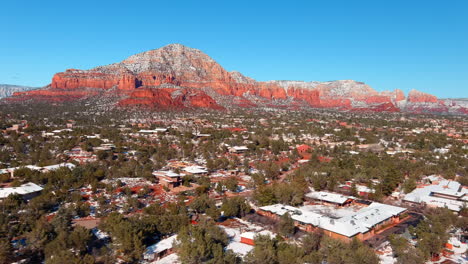Sedona-Town-during-Winter-with-Snow-Capped-Red-Rocks,-Aerial