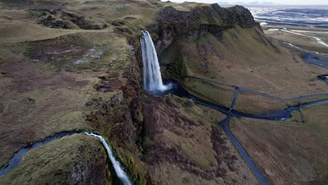 Cinematic-drone-establisher-impressive-waterfall-Seljalandsfoss-in-Iceland
