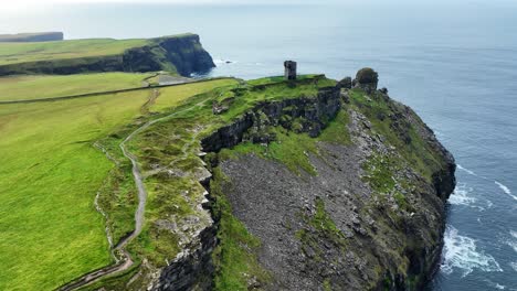 Drone-wild-Atlantic-Way-Cliffs-of-Moher-trail-leading-to-castle-on-the-clifftop-winter-in-Ireland
