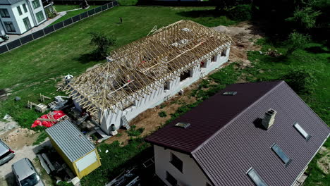360-degree-view-of-a-under-construction-house-with-wooden-frame-for-the-roof-near-other-houses