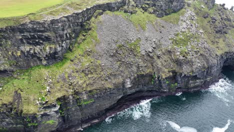 Drone-West-Of-Ireland-Cliffs-of-Moher-panning-shot-of-steep-cliffs-sea-caves-and-The-Wild-Atlantic-Ocean-on-a-winter-day-in-November