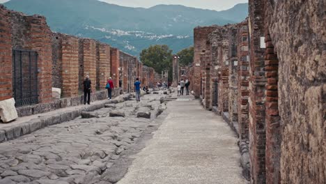 Tourists-exploring-Cobblestone-street-in-Pompeii,-Italy