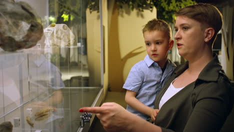 Madre-Mostrando-Artefactos,-Huesos-De-Animales-A-Su-Hijo-En-Un-Museo,-Primer-Plano