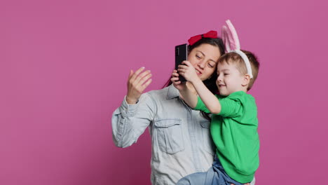 Lovely-small-child-taking-pictures-with-his-mother-on-smartphone