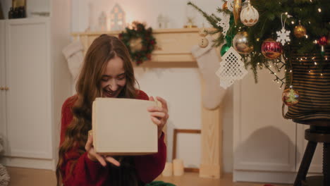 Woman-laughing-while-opening-Christmas-gift