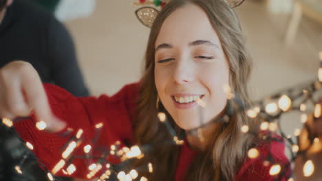 Woman-with-glowing-lights-by-friend-during-Christmas