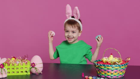 Smiling-cute-kid-playing-peek-a-boo-game-with-painted-colorful-eggs