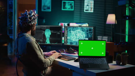 Ingenieur-Mit-EEG-Headset-Bei-Der-Zusammenführung-Mit-KI,-Laptop-Mit-Grünem-Bildschirm