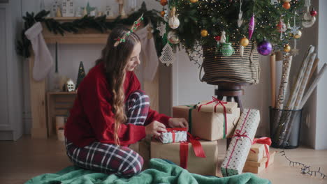 Schöne-Glückliche-Frau,-Die-Zu-Hause-Geschenke-Am-Weihnachtsbaum-Arrangiert