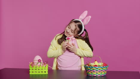 Cheerful-smiling-girl-hugging-her-stuffed-rabbit-toy-and-egg