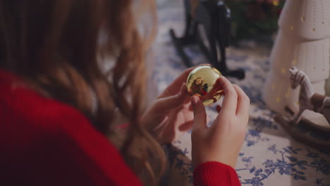 Woman-with-bauble-at-table-during-Christmas