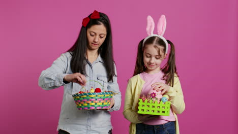 Joyful-confident-child-and-mother-showing-easter-baskets-on-camera