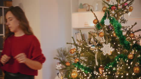 Frau-Bindet-Christbaumkugel,-Während-Sie-Den-Weihnachtsbaum-Schmückt