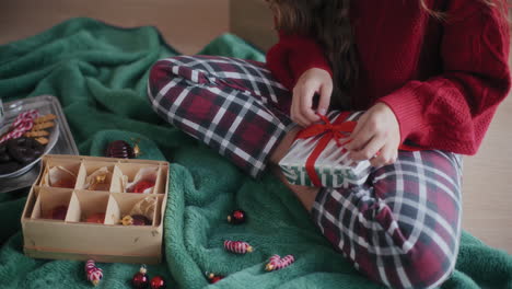 Woman-wrapping-Christmas-gift-on-floor-at-home