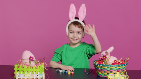 Young-small-kid-placing-bunny-ears-on-his-head-in-studio