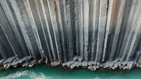 Canyon-of-basalt-columns,-cliff-with-turquoise-river,-in-Iceland,-aerial-shot