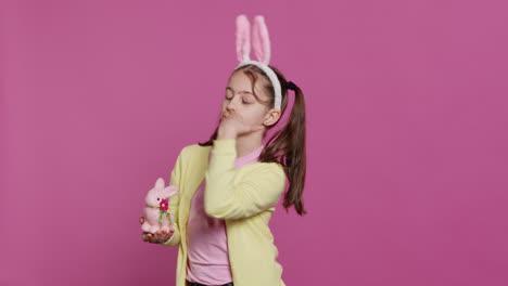 Lovely-little-girl-with-bunny-ears-sending-air-kisses-in-studio