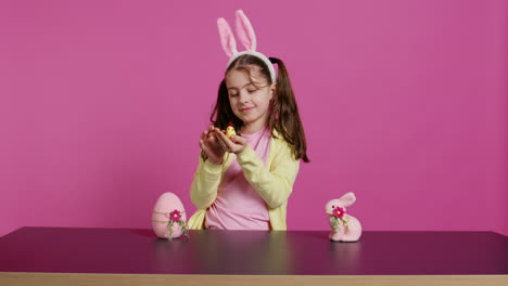 Joyful-little-girl-playing-with-festive-easter-decorations-in-studio