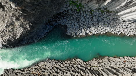 Turquoise-river-running-through-white-rock-formations,-aerial-directly-above