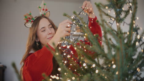 Mujer-Ajustando-Luces-LED-En-El-árbol-De-Navidad