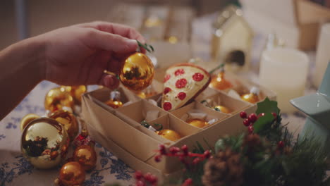 Man-removing-bauble-from-box-at-table
