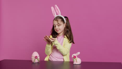 Joyful-little-girl-playing-with-festive-easter-decorations-in-studio