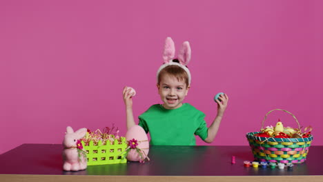 Smiling-cute-kid-playing-peek-a-boo-game-with-painted-colorful-eggs