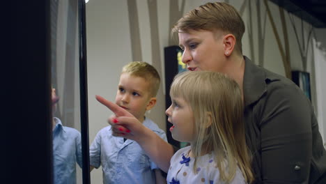 Family-having-fun-in-the-museum,-using-interactive-touch-screen,-medium-shot