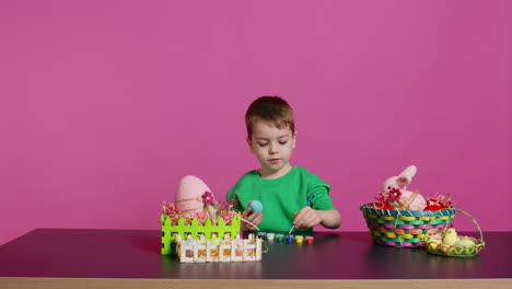 Un-Niño-Pequeño-Y-Alegre-Pintando-Huevos-Para-La-Festividad-De-Pascua-En-El-Estudio