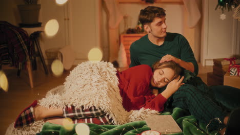 Woman-resting-on-boyfriend's-lap-sitting-on-blanket