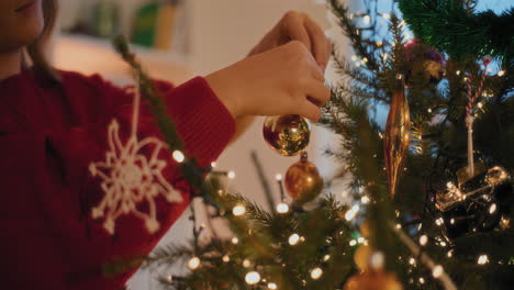 Woman-tying-bauble-while-decorating-Christmas-tree