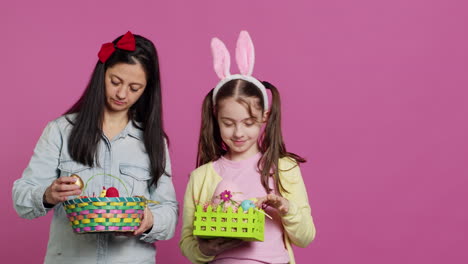 Joyful-confident-child-and-mother-showing-easter-baskets-on-camera