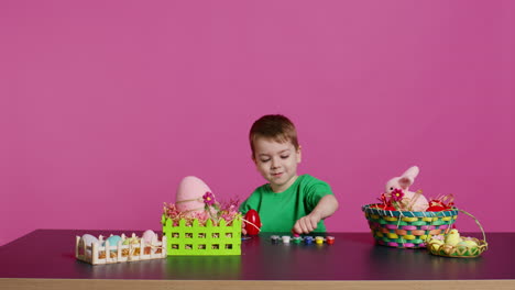 Ecstatic-little-kid-using-watercolor-and-paintbrushes-to-decorate-eggs