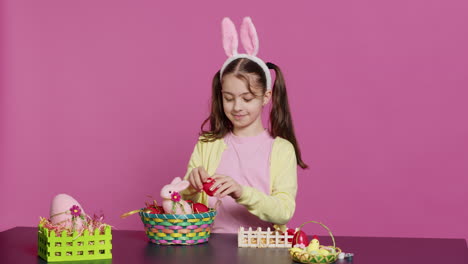 Cute-smiling-toddler-decorating-a-basket-with-painted-easter-eggs